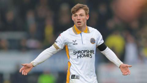 Tommi O'Reilly stretches his arms out wide asking for the ball during a game for Shrewsbury Town