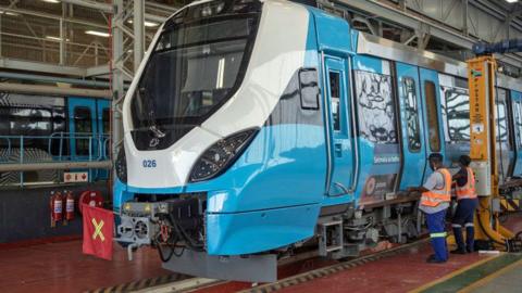 Workers inspect a train at a Prasa depot near Pretoria, South Africa - 2021