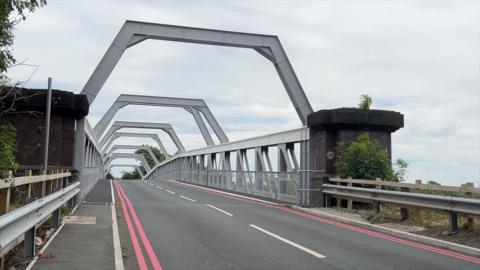 A view of the Warburton toll bridge. It is a metal framed bridge.