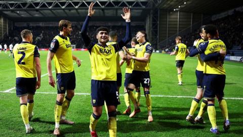 Yunus Emre Konak of Oxford United raises his arms in the air and celebrates with his team-mates after they scored a goal at Preston.