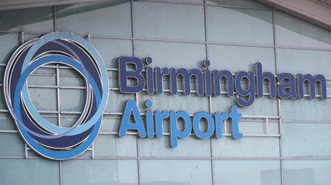 Birmingham Airport exterior, with logo and Birmingham Airport in blue signage. 