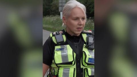 Lucy D'Orsi has blonde short hair in a ponytail and wears a BTP police vest
