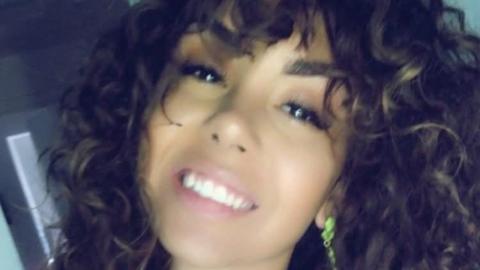 A young woman smiles at the camera