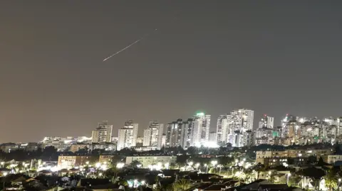 A streak of light, that appears to be an Iranian missile, seen in Israel oin 7 June