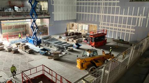 A large room inside Becketwell Arena, full of construction equipment