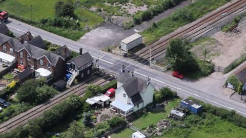 Aerial viewing of a railway crossing through houses