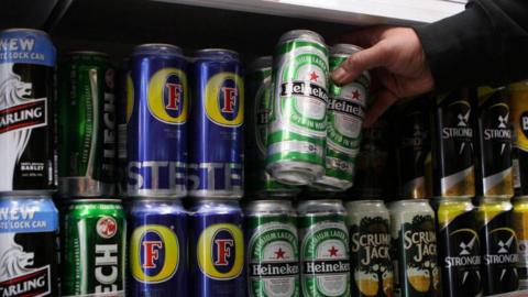 A general view of cans of lager and cider on a shop shelf