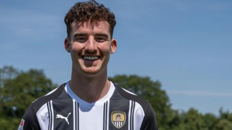 Luka Smyth poses for a picture in Notts County colours after joining the League One side