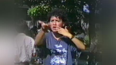 A deaf student using sign language while outdoors