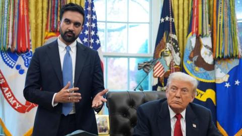 Zohran Mamdani gestures as he speaks standing next to a seated Donald Trump in the Oval Office.