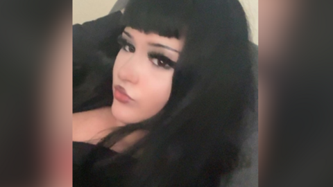 Lilly McCarthy who is taking a selfie. She has black hair with a full fringe and is looking directly at the camera.