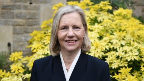 Anne Burnett with medium length fair hair wearing a black jacket