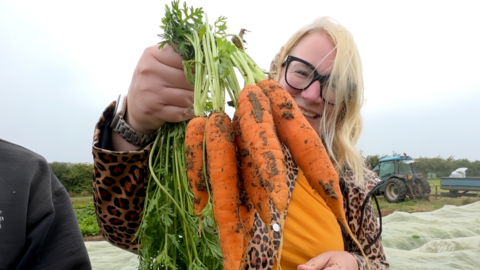 BBC Radio Oxford presenter Sophie Law holding some carrots and smiling at the camera