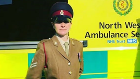 Rachel Claire Lemonofides  is in an amry unform in front of an ambulance with yelow and green livery.