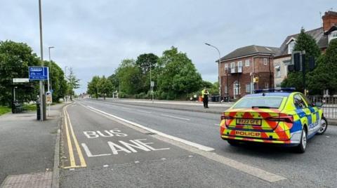 Police officer and car at scene of crash in Narborough Road in 2024