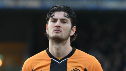 A close up of Zeno Ibsen Rossi wearing his orange and black Cambridge United kit during their game against Walsall in January