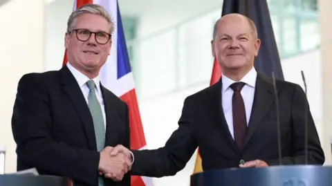 German Chancellor Olaf Scholz (R) shakes hands with British Prime Minister Keir Starmer (L) during a joint press conference at the chancellery in Berlin, Germany, 28 August 2024