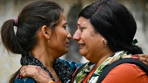 Women mourn as the bodies of their relatives, killed the previous day after Air India flight 171 crashed in a residential area, are taken out of a hospital mortuary in Ahmedabad on June 13, 2025. Rescue teams with sniffer dogs combed the crash site on June 13 of a London-bound passenger jet which ploughed into a residential area of India's Ahmedabad city, killing at least 265 people on board and on the ground. (Photo by Punit PARANJPE / AFP) (Photo by PUNIT PARANJPE/AFP via Getty Images)