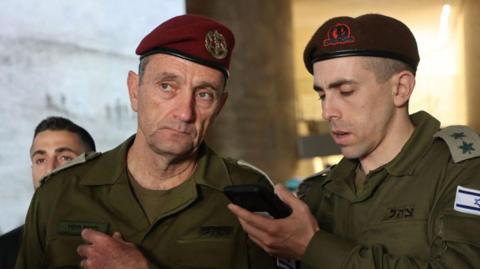 Israeli military chief Lt Gen Herzi Halevi (L) listens to a message during a Memorial Day ceremony at Jerusalem's Mount Herzl military cemetery on 13 May 2024 (file photo)