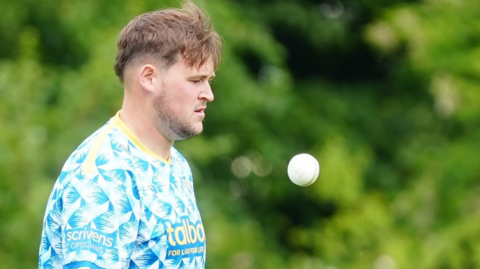 Adam Sylvester throws himself a catch as he prepares to start his run-up during a T20 game for Warwickshire