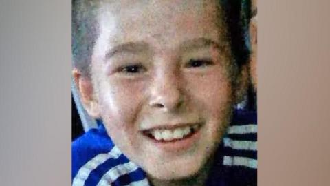 Shea Ryan is pictured smiling and wearing a blue top with white stripes.
