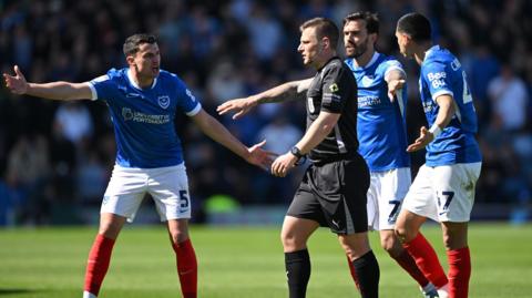 Portsmouth players appeal to the referee during their match with Oxford United