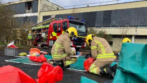 Fire crews deal with the aftermath of the most recent fire at the site