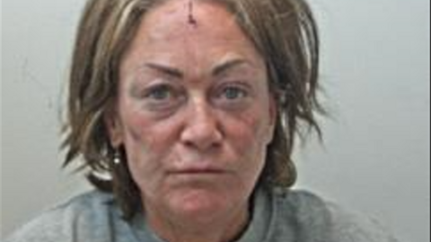 A police mugshot of a dishevelled looking Nicolette Goldrick