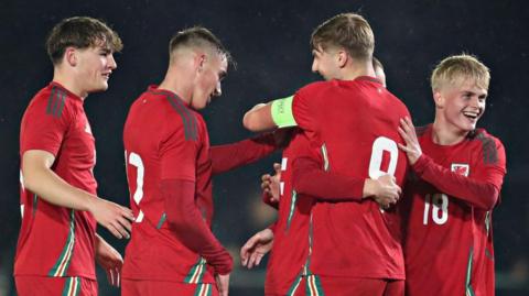 Wales players celebrate a goal against Japan