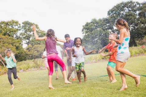 children have a water fight on a playing field