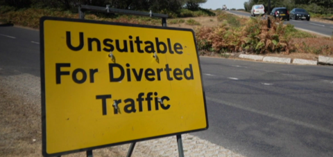 A yellow traffic warning sign for diverted vehicles