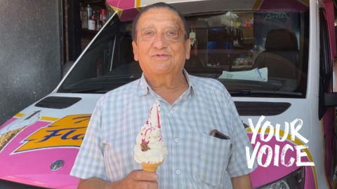 Dipak Davda, 72, wearing a grey shirt holding an ice cream in front of his ice-cream van in Leicester.