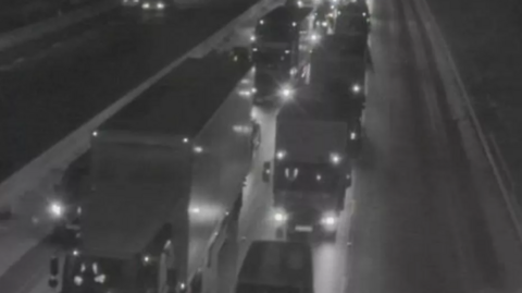 The lights of lorries show up in the dark with traffic at a standstill on the M6 southbound