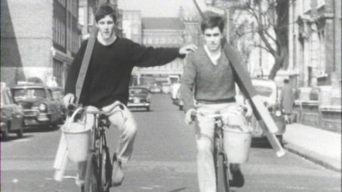 Pat and Mike on bicycles carrying ladders