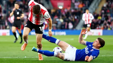 Leif Davis slides in to tackle Southampton's Tom Fellows