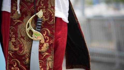 A stock image of a cosplayer with a pirate's sword