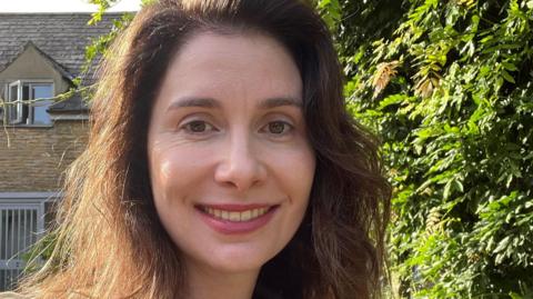 Laura Horwill, stood outside, smiling at the camera