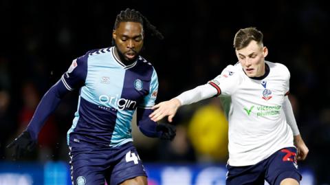 Wycombe's Fred Onyedinma and Bolton's Szabolcs Schon battle for the ball