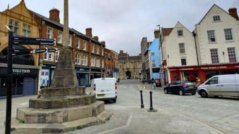 A picture of the war memorial in Grantham market place with all the road newly surfaced with cobbles and setts.