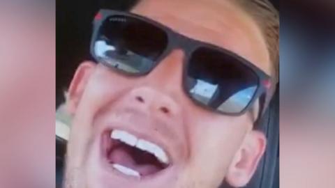 Man with sunglasses smiles into the camera.