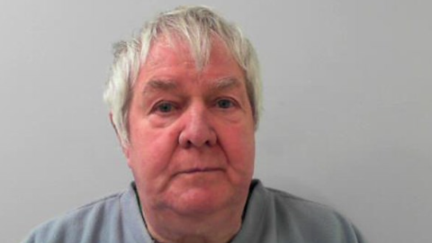 A police mugshot of Rodney Abbott, an elderly man with short grey hair wearing a grey jumper.