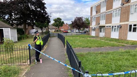 Police officer outside block of flats