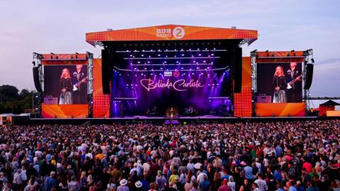 wide shot of crowds watching Belinda Carlisle on stage