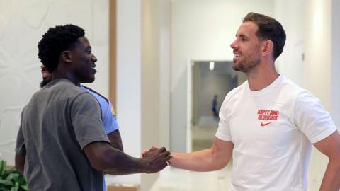 Kobbie Manoo and Jordan Henderson greet each other 