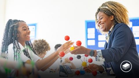 A photograph of high school students learning about molecules with a structure in a science class.