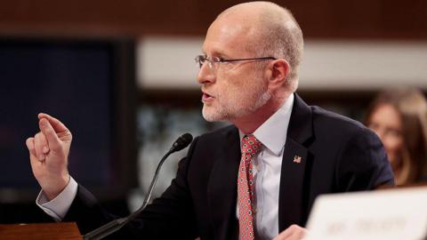 Brendan Carr speaking into a microphone and pointing his finger