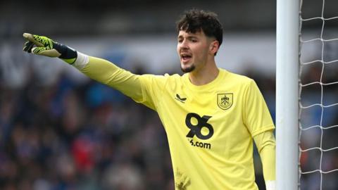 James Trafford delivers instructions to Burnley team-mates with his arm raised