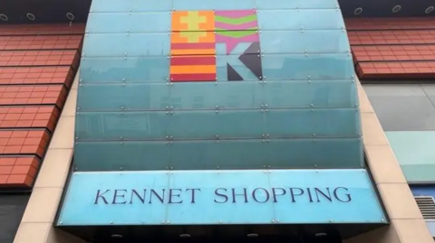 A picture outside the Kennet Shopping Centre in Newbury, with a shop bordering it on its left and a Caffe Nero on the right.