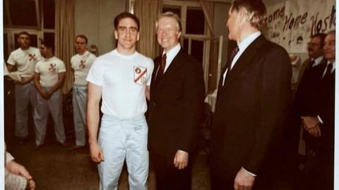 Rocky Sickmann, a Marine in pyjamas, stands next to President Jimmy Carter while others look on