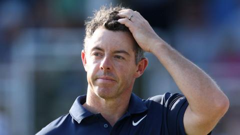 Rory McIlroy holding a hand to his head